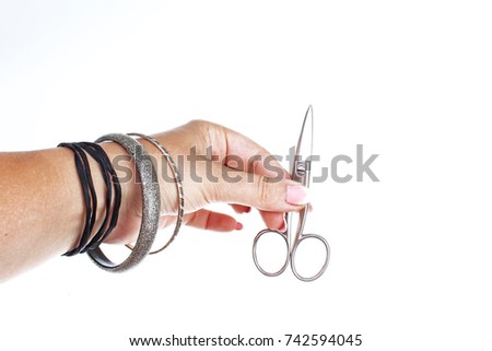 Woman hand holding cosmetic scissors on isolated white cutout background. Studio photo with studio lighting easy to use for every concept.