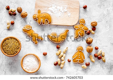 Healthy food for sportsman. Cookies in shape of yoga asanas near nuts on stone background top view