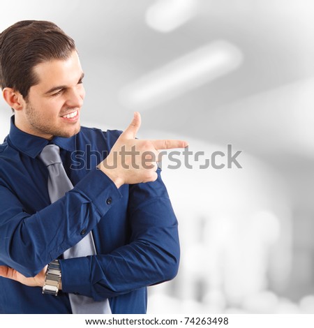 Young handsome businessman pointing to something using a finger
