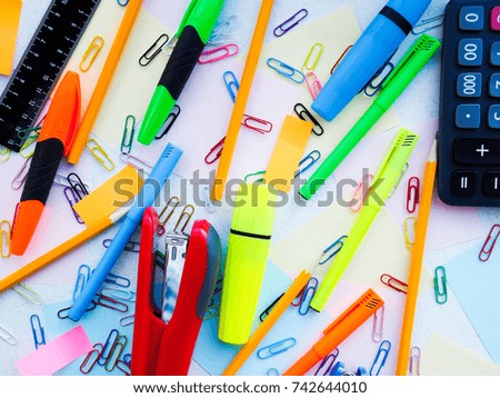 stationery stapler, paper clips, notes, pens and pencils on the table