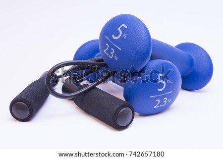 Jumprope and blue dumbbells on white isolated background Royalty-Free Stock Photo #742657180
