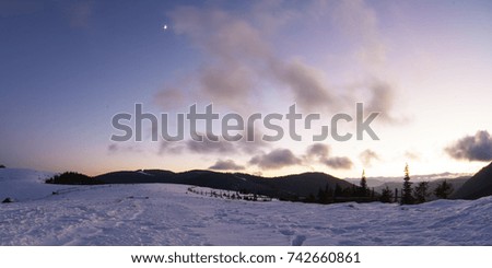 Winter Carpathian mountains and a village before sunrise, panoramic view, rural landscape