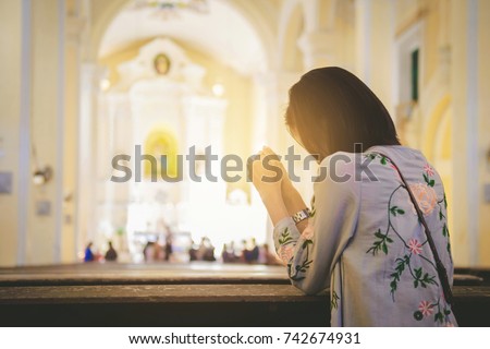 Girl praying worship in a church. Hands folded in prayer, Hope and Religion Concept