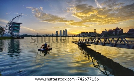 Jetty at lakeside with colourful Sunrise, Pullman, Putrajaya, Malaysia. Image has grain or blurry or noise and soft focus when view at full resolution (Shallow DOF, slightly motion blur).