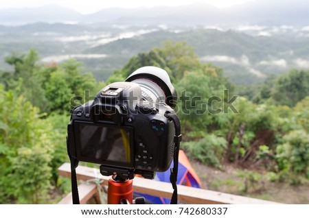 DSLR Camera set on camera tripod for take a landscape photo in selective focus.