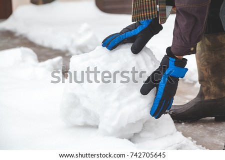 Hands in the ski gloves creates a snowball winter day
