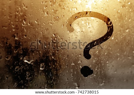 Autumn rain, an inscription on sweaty glass - a question mark illuminated by the sun's rays