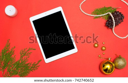 Computer laptop mobile display on table with isolated white screen for mockup in Christmas time. Christmas tree, gifts, decorations in background.