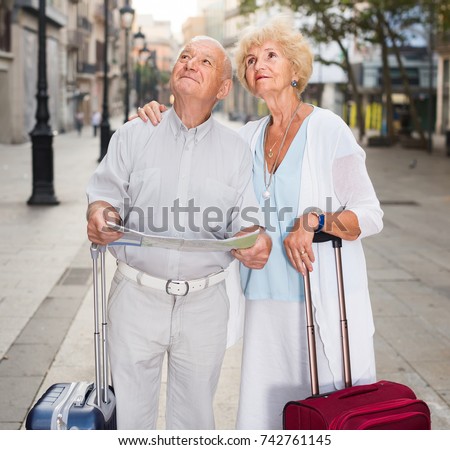Senior germany  woman and man traveling together looking for destination with city map
