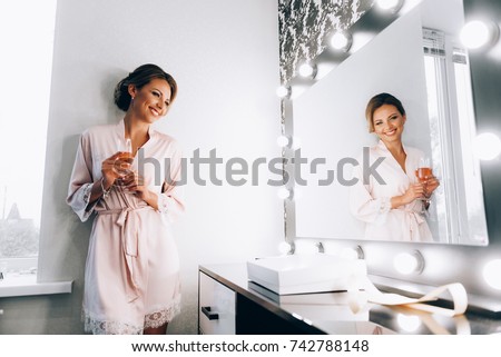 morning of the bride. The bride in front of the mirror in her dressing gown. Royalty-Free Stock Photo #742788148