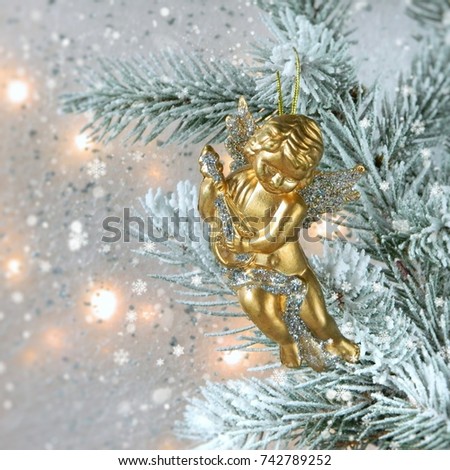 Christmas card with golden angel playing on a mandolin on a Christmas tree. Place for text. Christmas card.