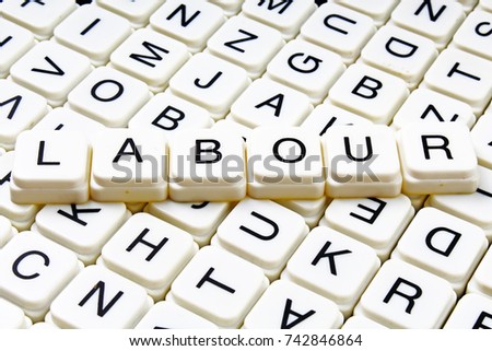 Labour text word crossword. Alphabet letter blocks game texture background.