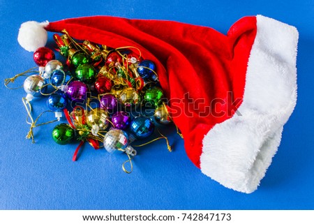 Beautiful Christmas hat, presents and Christmas balls on a red cap. Lie on a blue background