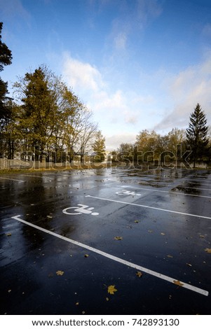 empty parking place with parking space for disabled in autumn