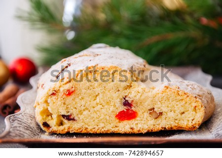 Christmas Stollen served on vintage tray on a wooden background. Festive european baking.