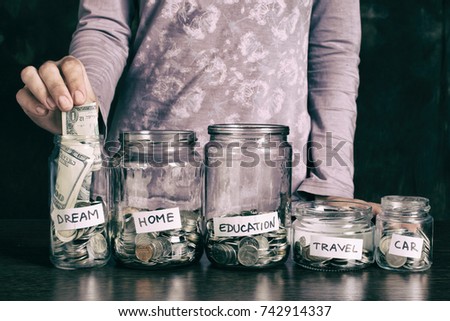Hand's women putting coin in money jar with text . Concept of investments, insurance, savings plans.