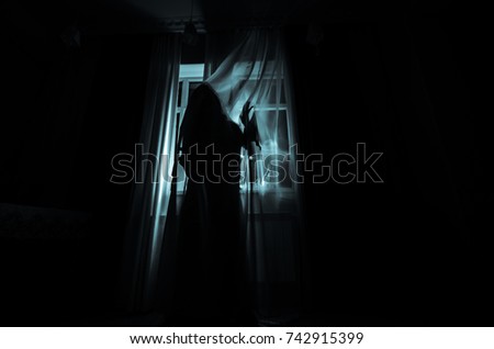 Horror woman in window wood hand hold cage scary scene halloween concept Blurred silhouette of witch. Horror theme