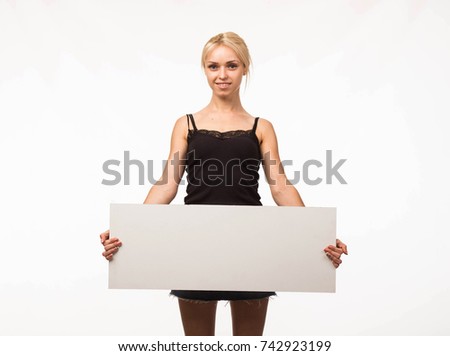 Young cheerful woman portrait of a confident businesswoman showing presentation, pointing placard gray background. Ideal for banners, registration forms, presentation, landings, presenting concept.