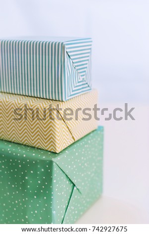 Vertical picture of three present boxes with modern packaging pattern and colors.