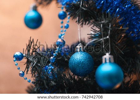 Christmas tree on wall background, yellow lights, blue Christmas toys