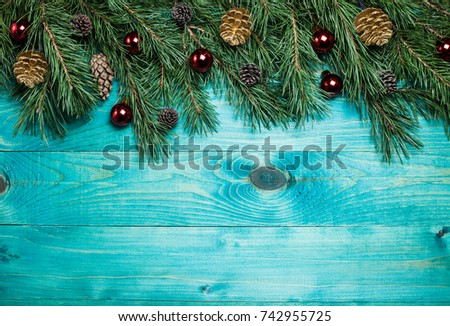 Christmas background with fir tree and decoration on blue wooden board. Christmas, New Year's composition with copy space for text. Flat lay, top view