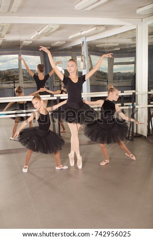 Three girls ballerinas perform exercises and pose in the hall for choreography