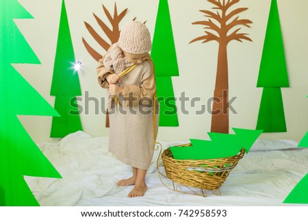 A boy with a handmade Christmas tree in sled