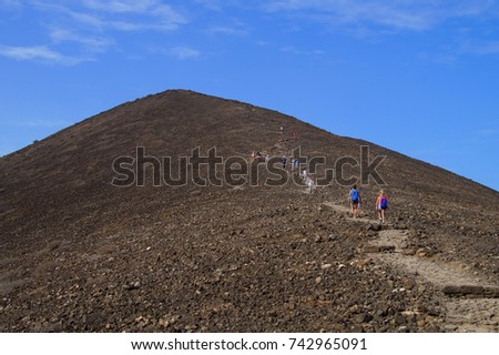 Tourists climbing Caldera Mountain, Lobos Island, Fuerteventura, Spain.