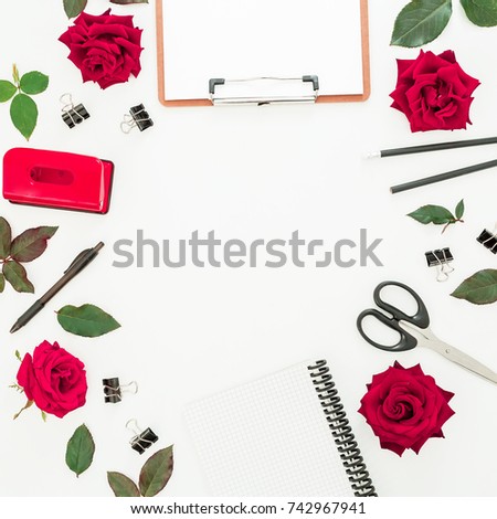Blogger or freelancer feminine desk workspace with clipboard, notebook, red roses and accessories on white background. Flat lay, top view.
