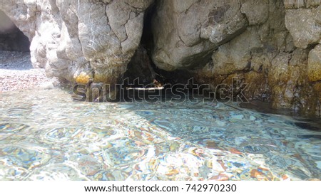 Sea level photo of turquoise clear water seascape full of caves