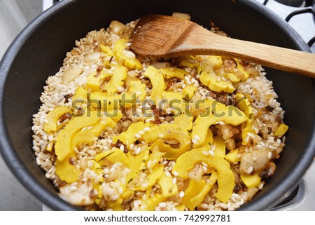 Making delicious squash risotto in a pan on the stove