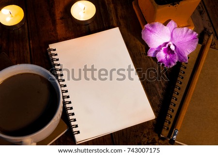 Books and pencils are placed on the table decorated with beautiful small candles to add color to the picture and also purple flowers make it even more attractive.