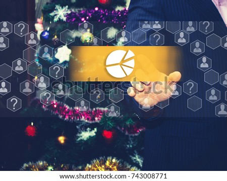 The businessman chooses chart, business diagram,   on the touch screen, the backdrop of the Christmas tree and decorations. Special toning .