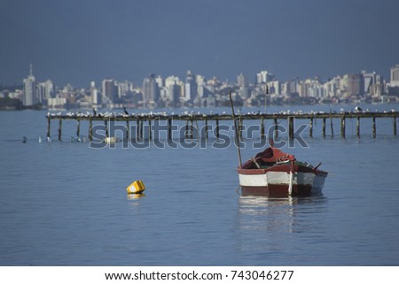 Lonely traditional greek fishing boat on sea water, Florianópolis island, Santa Catarina, Brazil.