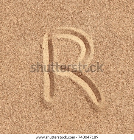 Handwritten letter r alphabet on a beach sand