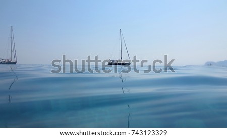 Sea level photo of yacht docked in turquoise and sapphire seascape