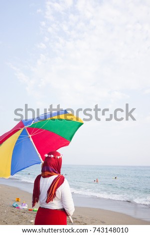 Arabic girl with parasol on beach