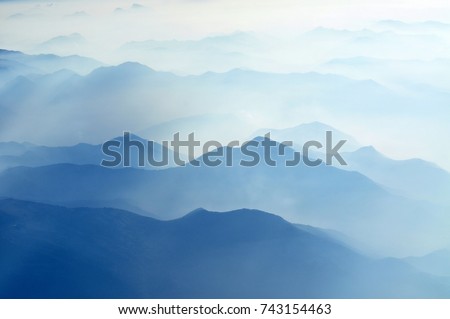 foggy morning in italian mountains - silhouettes on maintain range Royalty-Free Stock Photo #743154463