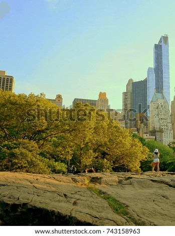 The girl is standing on the rock in Central Park, New York City, USA