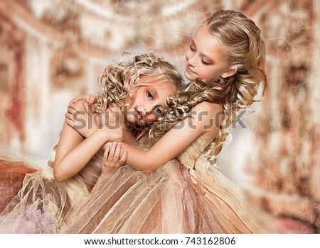 Sad blonde fashion sisters in the ball gowns
