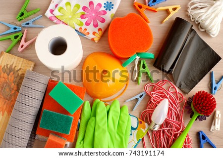 Many household utensils. Toilet paper, rubber gloves, garbage bags, laundry rope, light bulbs, rubber napkins, clothespins are household items. View from above. Household goods are scattered. Royalty-Free Stock Photo #743191174