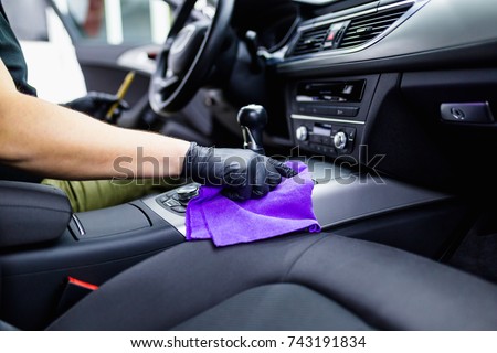A man cleaning car interior, car detailing (or valeting) concept. Selective focus.  Royalty-Free Stock Photo #743191834