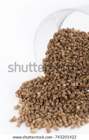 Buckwheat groats in a glass on light background