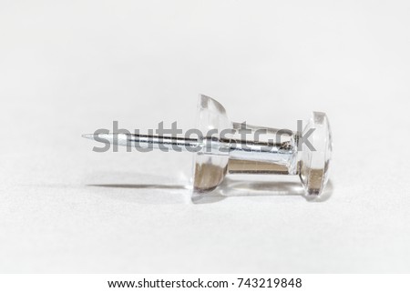 Single thumb tack or push pin on a white background macro