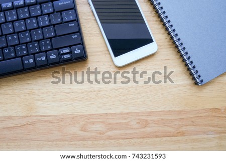 Flat Lay of Keyboard, Smartphone, and Notebook on Wooden Table Top View