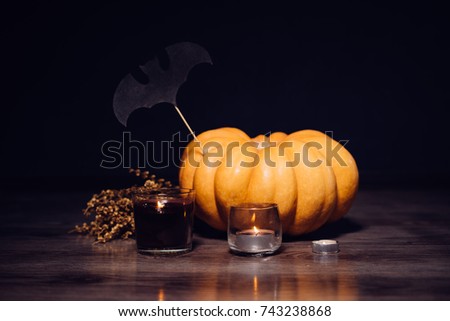 a composition for decorating a house for halloween, orange pumpkins, and burning candles