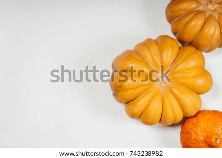 composition for decorating a house on halloween, on a white table lie orange and yellow pumpkins, 