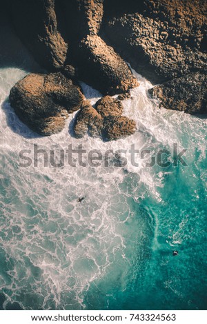 Body board in the water near rock in the sea