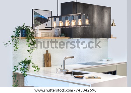 Modern kitchen design in home interior. Facades are painted and made of natural stone. Project management. Loft Light Fixture Lights in Black Metal Frame Shade with Clear Panel Glass. Copper Wire.