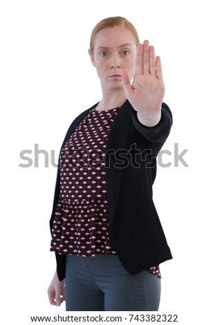 Young female executive making stop sign against white background